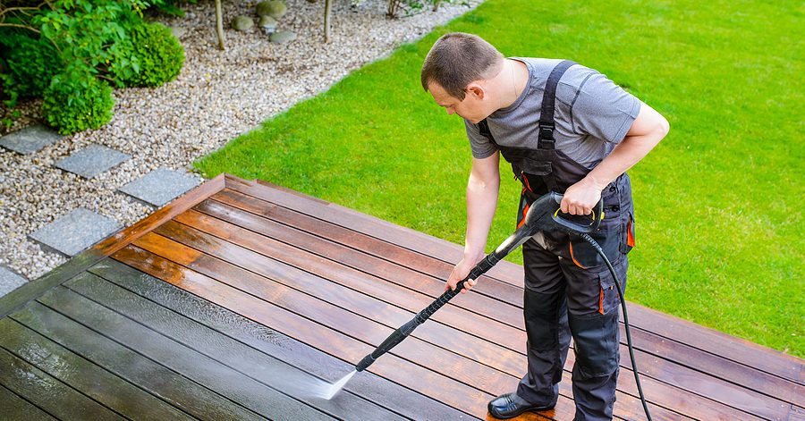 Pressure washing a wood deck during deck cleaning